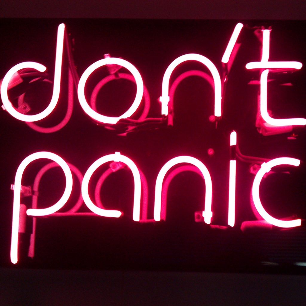 A neon sign that says don 't panic.