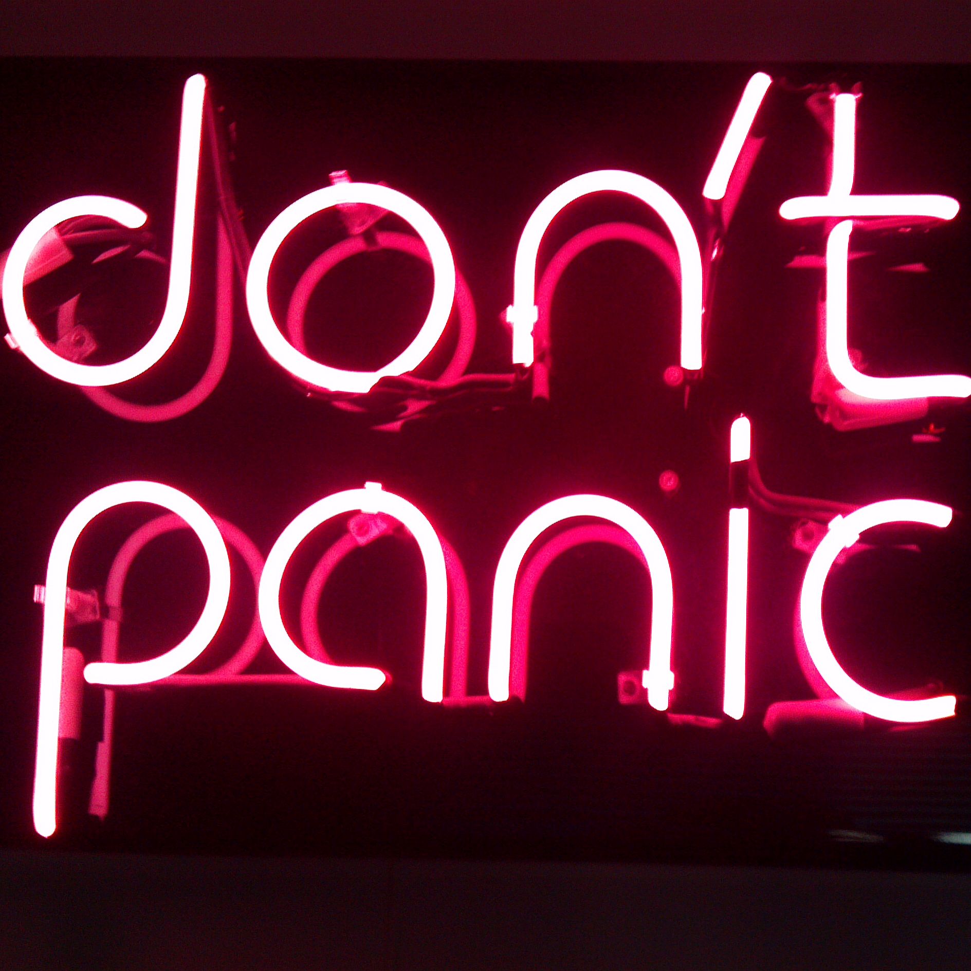 A neon sign that says don 't panic.