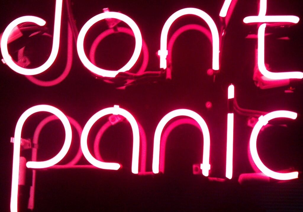 A neon sign that says don 't panic.